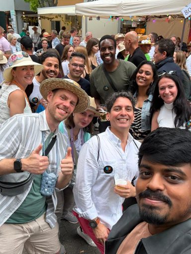 Eine Gruppe von Menschen lächelt in einer fröhlichen Atmosphäre bei einem Event.