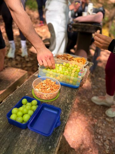 Eine Auswahl an Snacks: Trauben und Brezeln auf einem Tisch im Freien.