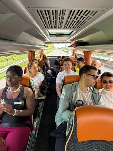 Bus mit Fahrgästen, die entspannt in den Sitzen sitzen und miteinander sprechen.